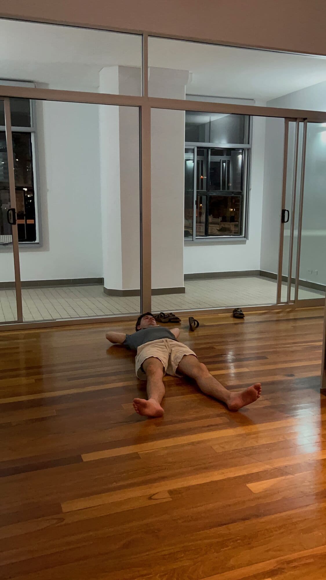 Ed lying down on the floor in the apartment